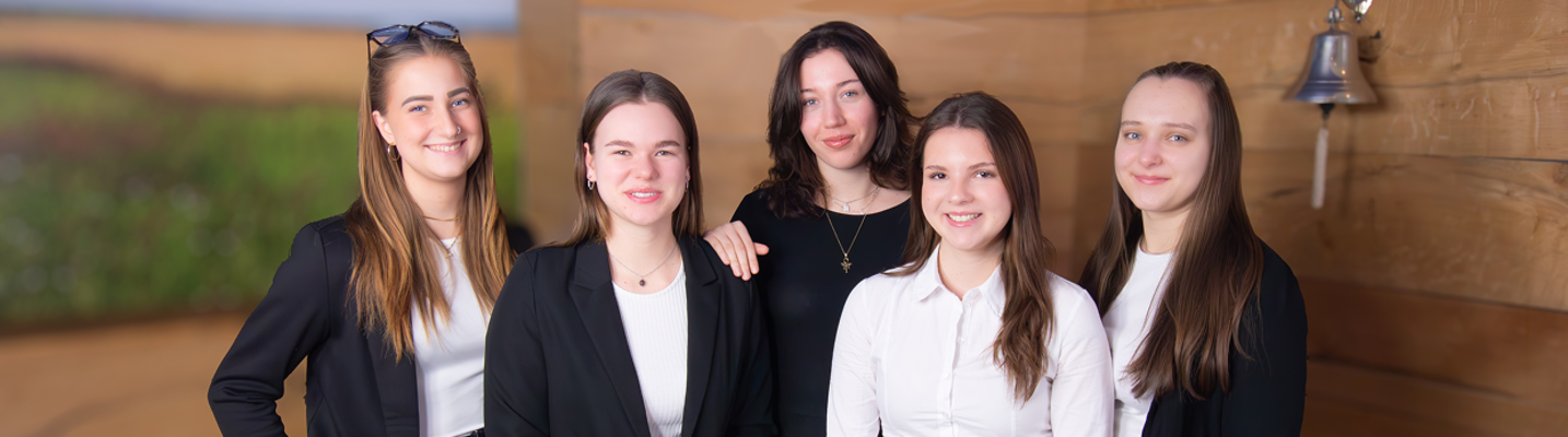 5 Auszubildende stehen nebeneinander und schauen in die Kamera