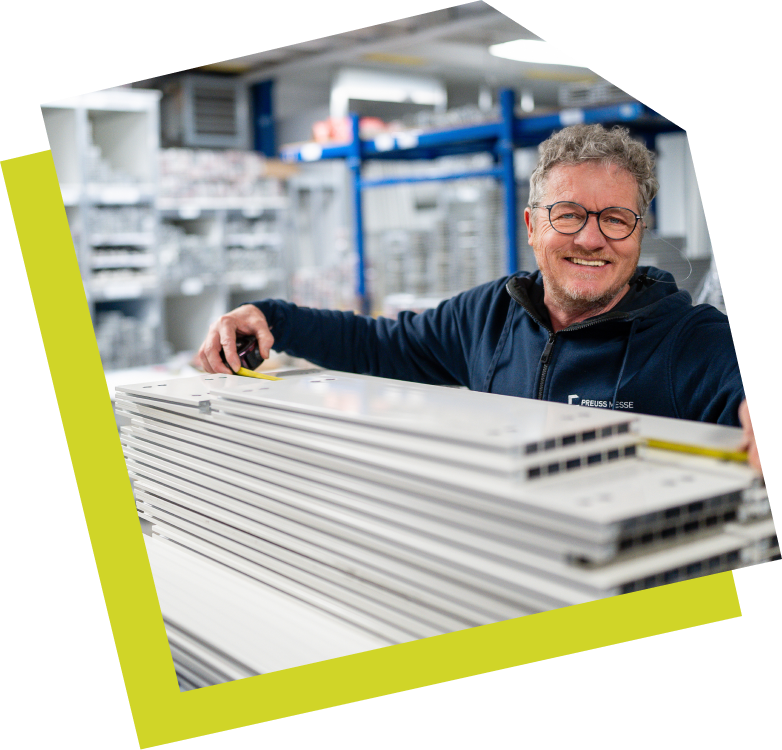 Bild eines Mitarbeiters von Preuss Messe aus dem Lager. Der Mitarbeiter guckt fröhlich in die Kamera